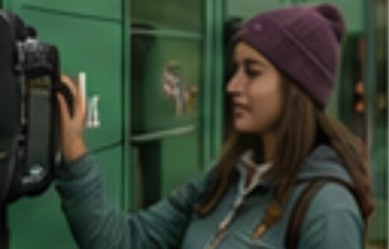 Visiteuse ouvrant un casier CAMP+ avec son téléphone